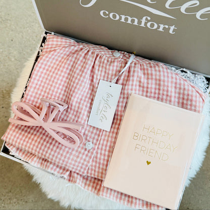 Cute ruffle pink and ivory gingham cotton pajama set, paired with a cute matching hair clip and birthday card that says Happy Birthday Friend. All packaged in a beautiful gift box. 