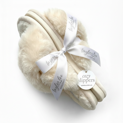 Pair of cream-colored slippers with a white ribbon and &