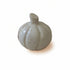 A hand-carved stone pumpkin with natural stone colors including shades of cream, gray, pink, and brown.