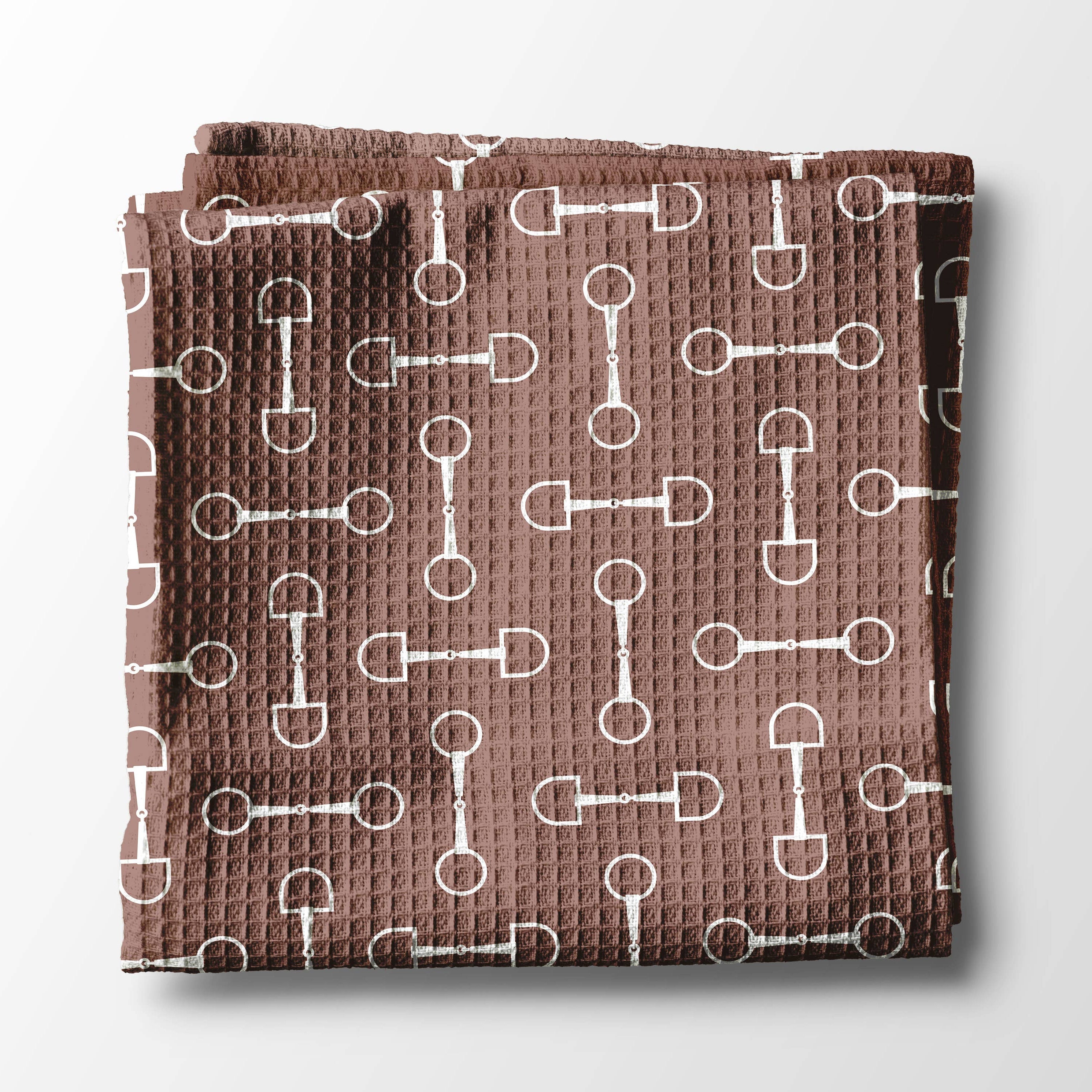 Folded brown kitchen towel with white pattern of horse bits. Kentucky theme and Useful gift