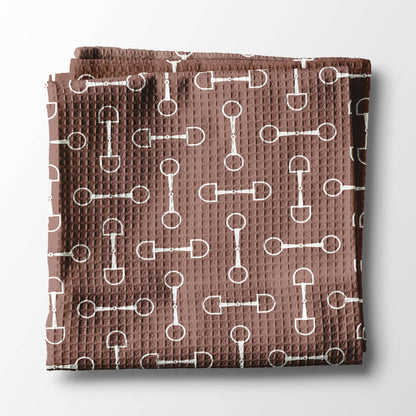 Folded brown kitchen towel with white pattern of horse bits. Kentucky theme and Useful gift